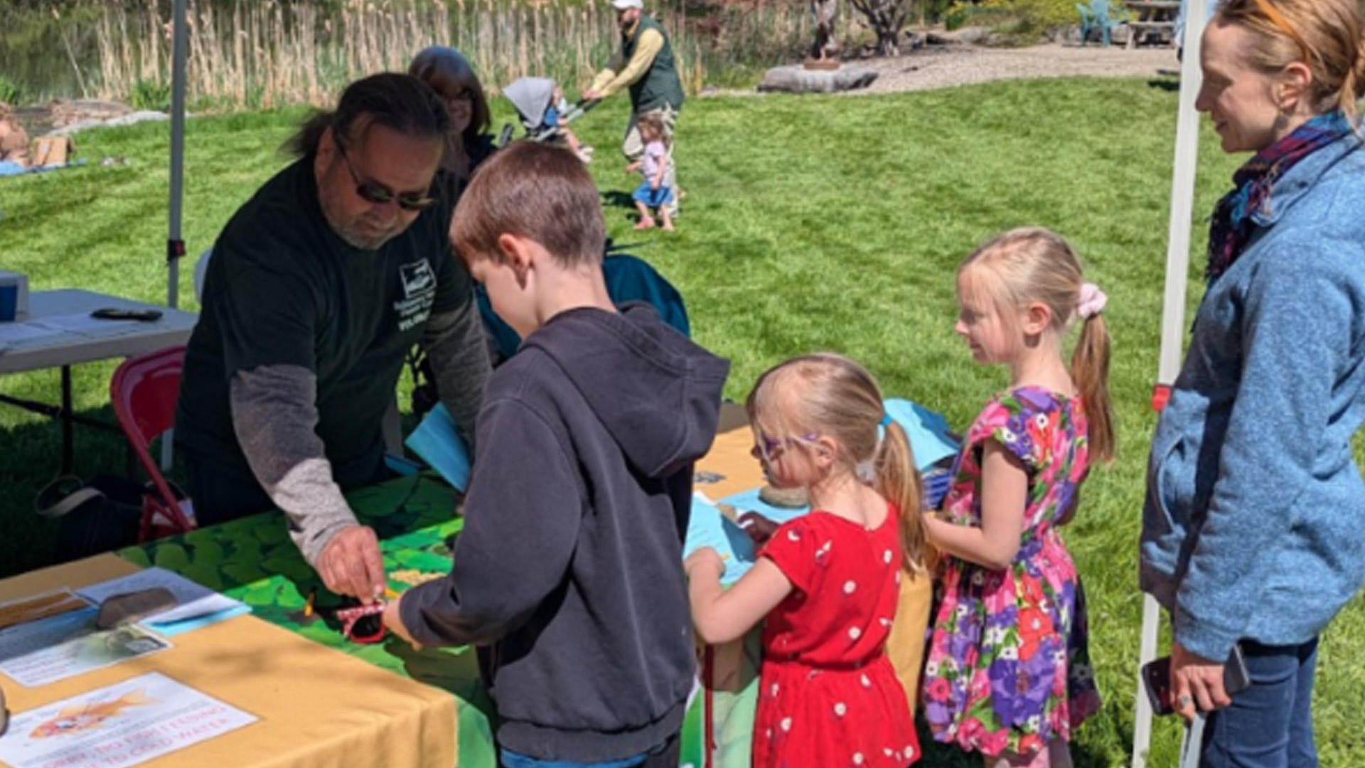 volunteer helping children at an outdoor event